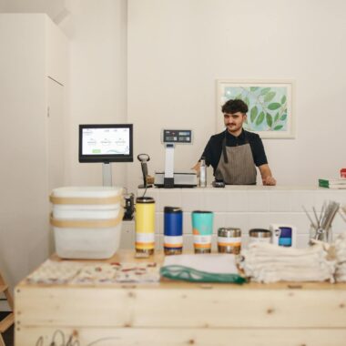 A modern retail store featuring eco-friendly, zero-waste products and a smiling cashier.
